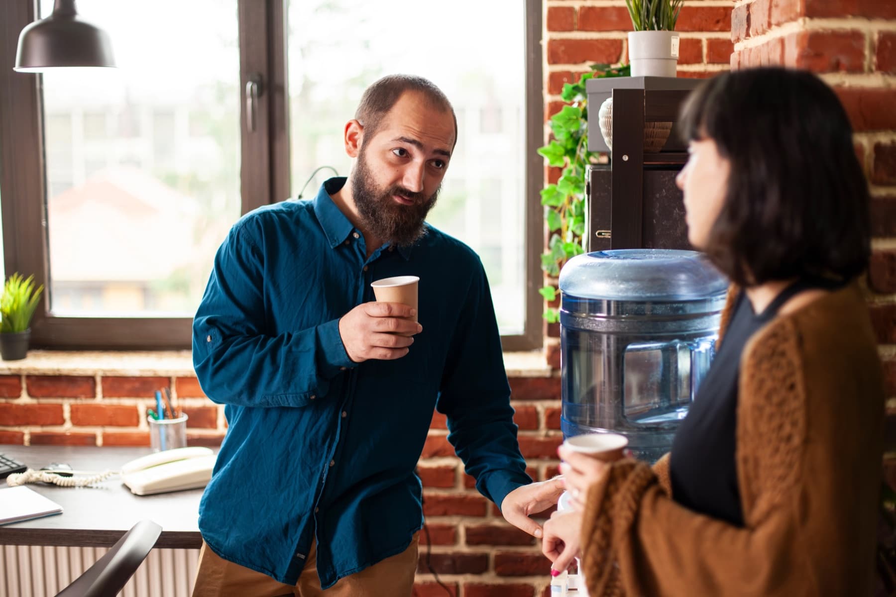 Colleagues beside a workplace water dispenser